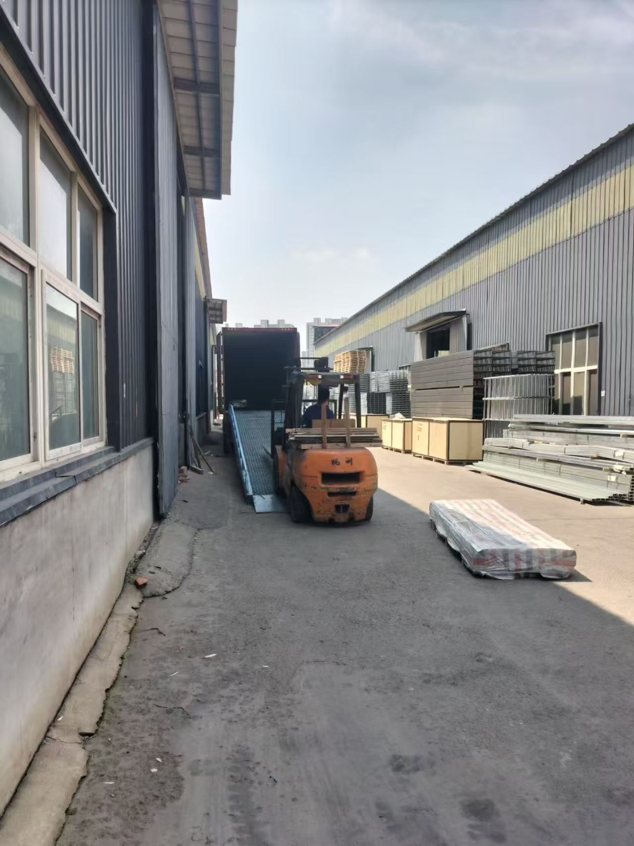 Forklift loading packed tray bundles into a container