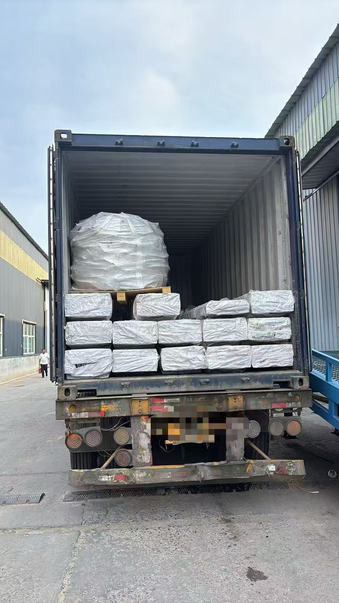 Container fully loaded with wrapped cable tray bundles, ready to seal